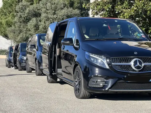 Flotte de Mercedes Classe V noires alignées Cannes Driver, portes ouvertes prêtes pour un évènement